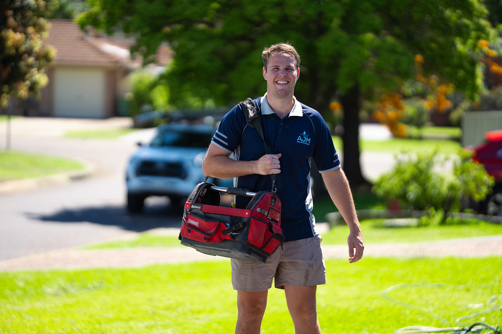 Aaron from AJM Plumbing Solutions walking up to a Sydney home with his tool bag